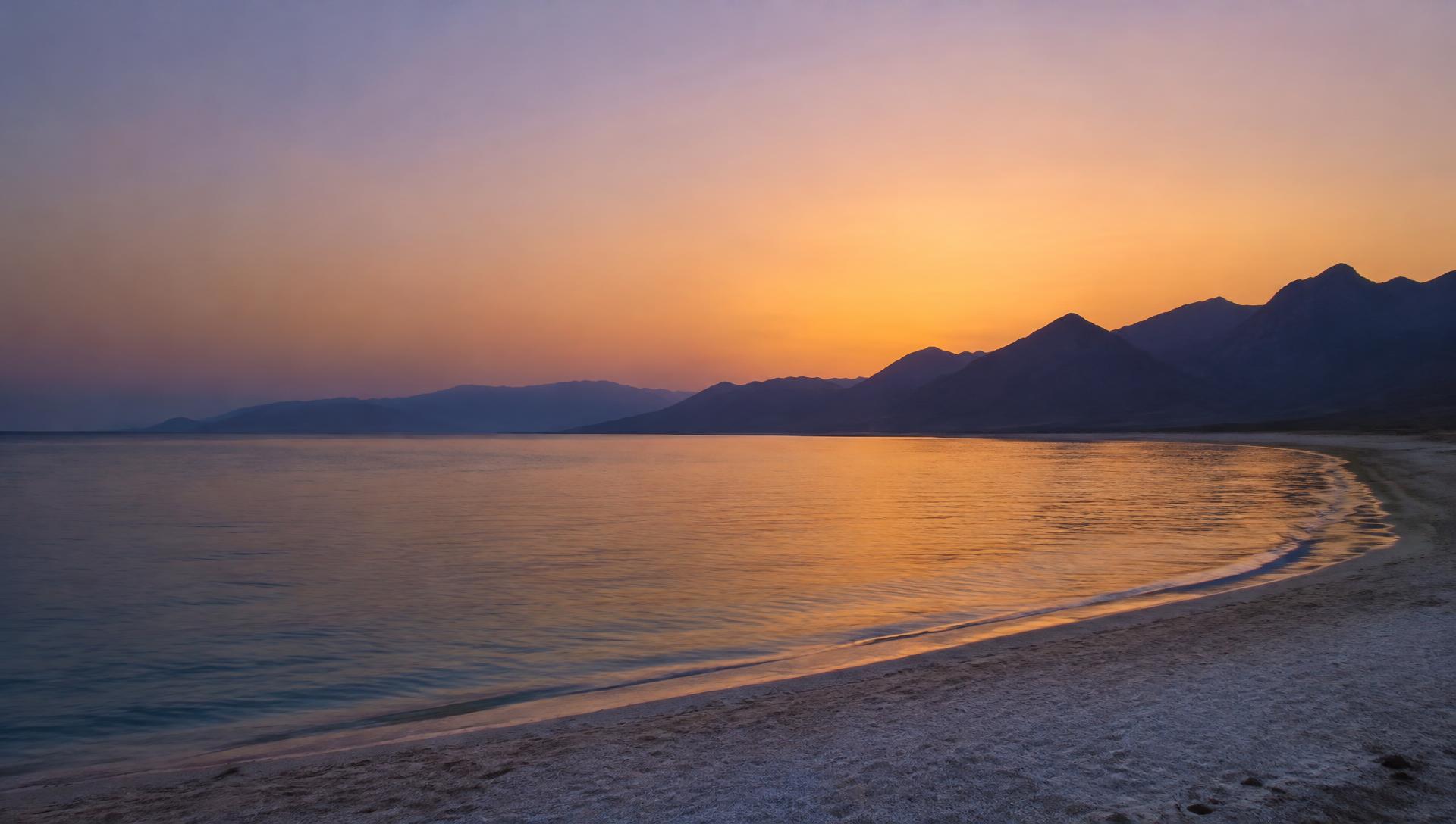 The Red Sea coast at dusk beneath silhouetted mountains